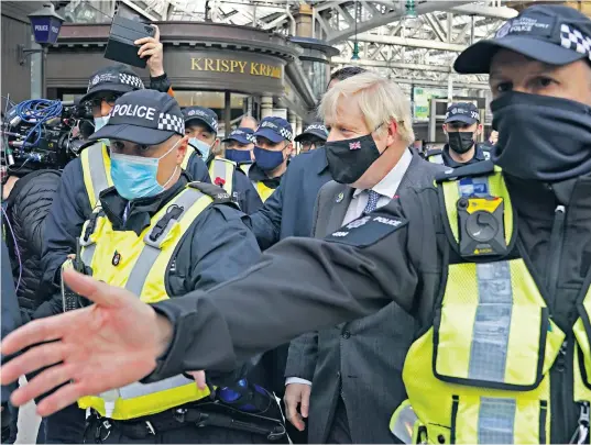  ?? ?? Boris Johnson is escorted by police as he arrives by train in Glasgow to attend the Cop26 summit yesterday