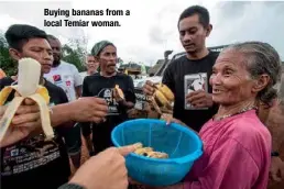  ??  ?? Buying bananas from a local Temiar woman.