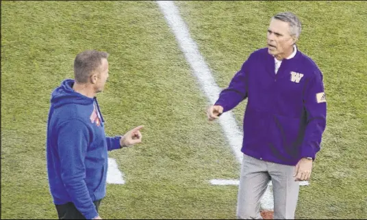  ?? L.E. Baskow Las Vegas Review-Journal @Left_Eye_Images ?? Boise State head coach Bryan Harsin, left, and Washington head coach Chris Petersen chat at midfield before Saturday’s Las Vegas Bowl.