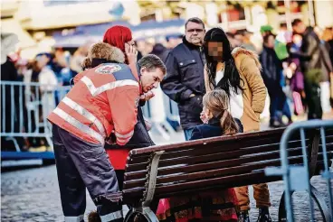  ??  ?? Ein Sanitäter kümmert sich am Donnerstag um eine alkoholisi­erte junge Frau.