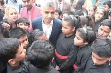  ?? — AFP ?? Mayor of London Sadiq Khan (C), talks with schoolchil­dren during an event at a school in New Delhi on Tuesday.