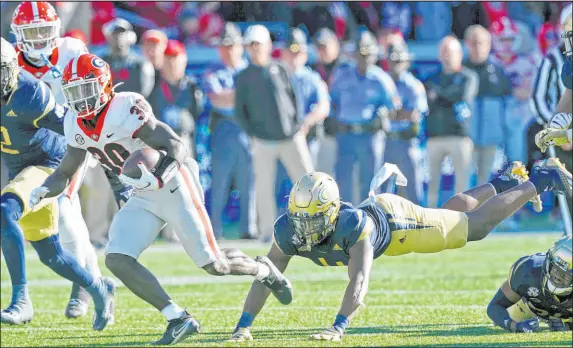  ?? John Bazemore The Associated Press ?? Georgia running back Zamir White breaks through the Georgia Tech defense during the Bulldogs’ 45-0 win on Nov. 27 in Atlanta.