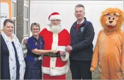  ??  ?? Lion Kim Harty, EKH dementia matron Joy Marshall, Santa, Lions president Philip Watson and Roary The Ashford Lions mascot raised £3,000 for a new sensory garden at the William Harvey Hospital through their Santa Sleigh