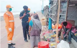  ??  ?? Crews from India’s National Disaster Response Force warn people on the Bay of Bengal coast about Cyclone Amphan. The powerful cyclone is expected to hit India’s West Bengal state and Bangladesh today.