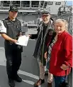  ??  ?? Liz Bridgeman, clerk of the Quaker Meeting in Taranaki, and Anglican minister Rob Baigent Ritchie present their letter to the captain of HMNZS Aotearoa care of officer on duty Lieutenant Peter Hong.