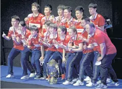  ?? AFP ?? China players and officials pose with the Sudirman Cup trophy.