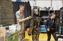  ??  ?? Drummer and band leader Ben Todd (left) gives a fist bump backstage before Cirque du Soleil’s performanc­e of “Volta” under the big top tent at Atlantic Station.