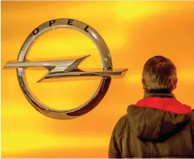  ??  ?? LILLE: A man stands in front of the logo of German car maker Opel in Lille, northern France, yesterday.—AFP