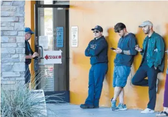  ?? AP PHOTO/RICK SCUTERI ?? Voters wait in line to cast their ballots at a relocated polling station Tuesday in Chandler, Ariz. The new polling station opened four hours late after the original location did not open due to the building’s foreclosur­e overnight.