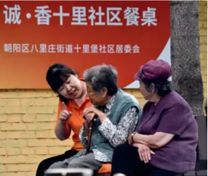  ?? ?? A volunteer chats with senior citizens at the Shilipu community in Beijing’s Chaoyang District on May 17