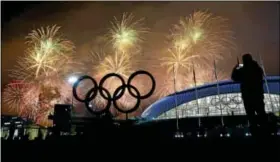  ?? Petr David Josek/The Associated Press ?? A man takes a photograph of fireworks during the closing ceremony of the 2014 Winter Olympics Sunday.