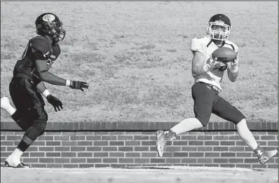  ?? Arkansas Democrat-Gazette/MELISSA SUE GERRITS ?? Minnesota-Duluth wide receiver Aaron Roth (right) catches a touchdown pass as Ouachita Baptist defender Devin Price gives chase during Saturday’s NCAA Division II playoff game at Cliff Harris Stadium in Arkadelphi­a.