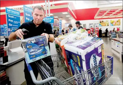  ?? NWA Democrat-Gazette/JASON IVESTER ?? Scott Leach of Rogers scans items at a self-checkout station Tuesday at Sam’s Club in Bentonvill­e. The company is working to build customer loyalty through private-label products.