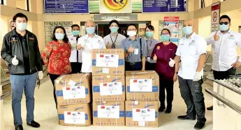  ??  ?? Fung (fourth left) handing over the face masks to acting Tawau Hospital director Dr Asbullah Sudin.