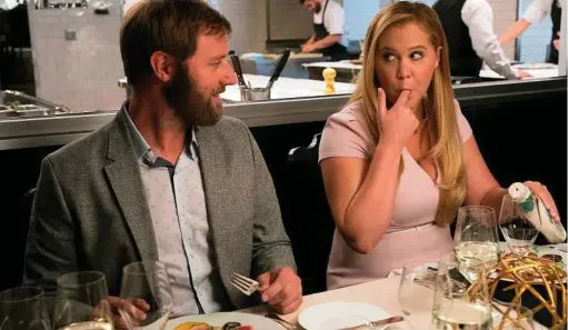  ?? Mark Schafer / STXfilms ?? Rory Scovel, left, and Amy Schumer in a scene from “I Feel Pretty,” in which Schumer’s character gains confidence after bumping her head and awakening to the belief that she has transforme­d into a supermodel.