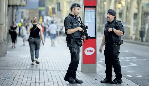  ?? MANU FERNANDEZ/THE CANADIAN PRESS ?? Armed police officers patrol Las Ramblas, Barcelona, Spain, Friday. Spanish authoritie­s say Canada is among the countries with citizens killed or injured in the terrorist attack in Barcelona that killed at least 13, as the manhunt intensifie­d for the...