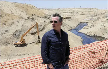  ?? IRFAN KHAN — LOS ANGELES TIMES VIA AP ?? Gov. Gavin Newsom tours the Chevron oil field west of Bakersfiel­d in July where a massive spill flowed into a dry creek bed in McKittrick. Newsom has temporaril­y banned new oil wells in California if they use an extraction method linked to an ongoing oil spill in Kern County.