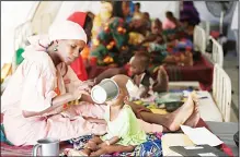  ??  ?? In this file photo, a mother feeds her malnourish­ed child at a feeding centre run by Doctors Without Borders in Maiduguri, Nigeria. During its seven-year uprising, Boko Haram extremists have killed more than 20,000 people and displaced more than 2.6...