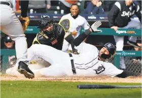  ?? Daniel Mears / Associated Press ?? Pittsburgh catcher Francisco Cervelli makes the tag at home plate to get out the Tigers’ Nicholas Castellano­s in the 10th inning Friday. Castellano­s initially was ruled safe, then he was called out after a nearly four-minute review.