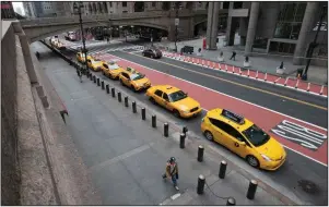  ?? (AP/Mary Altaffer) ?? New York City taxis wait for fares Wednesday on an empty 42nd Street outside Grand Central Terminal. Big cities are taking drastic action to slow the coronaviru­s spread, and now small towns and rural areas are beginning to sound the alarm. More photos at arkansason­line.com/326outbrea­k/.