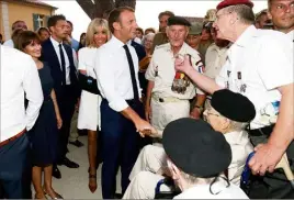  ??  ?? Brigitte Macron (en arrière-plan) accompagna­it son époux, avec un bras droit en écharpe dont la raison demeure inconnue.