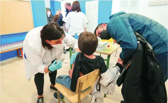  ?? EFE ?? Un padre acompaña a su hijo en la vacunación en un colegio de la Comunidad Valenciana