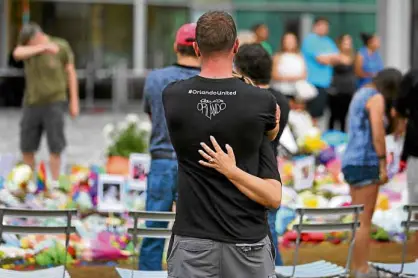  ?? AP ?? MOURNERS honor the Pulse nightclub victims at a makeshift memorial outside Dr. Phillips Center for the Performing Arts in downtown Orlando.