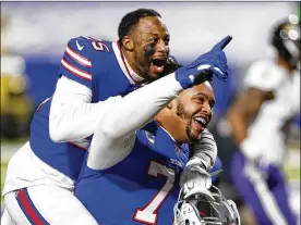  ?? JOHN MUNSON / AP ?? Buffalo Bills players Taiwan Jones (left) and Dion Dawkins celebrate after a playoff win Saturday night against the Baltimore Ravens. The victory has the Bills in the AFC title game for the first time since the 1993 season.