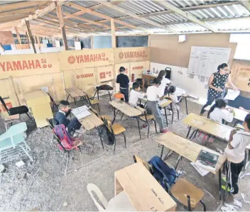  ??  ?? Los salones están improvisad­os con paredes de cartón y madera, así como piso de tierra. La primaria es una galera donde los maestros compiten todo el tiempo con sus compañeros para que los alumnos los escuchen.