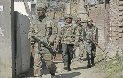  ??  ?? SRINAGAR: Government forces guard during a gun-battle at Haffo village, 43 kilometers south of Srinagar, India, yesterday. — AP