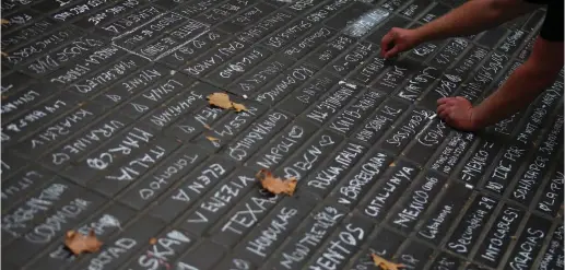  ?? (Reuters) ?? A PERSON writes messages on a sidewalk at Las Ramblas in Barcelona on Saturday.