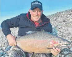  ??  ?? BIG HAUL: Trevor Holmes with his 12.2kg Tekapo rainbow trout.