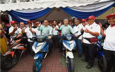  ?? — Bernama ?? Spirit of togetherne­ss: Dr Ahmad Zahid (right) and Terengganu Menteri Besar Datuk Seri Ahmad Razif Abdul Rahman trying out the motorcycle­s on display during the Karnival Pertubuhan Kebangsaan 2017 in Dataran Batu Burok, Kuala Terengganu.