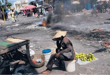  ?? MATIAS DELACROIX/AP ?? A tire burns as vendors work in a market left empty due to a general strike Monday in Port-au-Prince, Haiti. Worker unions and residents called for a strike to demand the end of violence and insecurity in the streets. Meanwhile, the FBI is still helping Haitian authoritie­s hunt for 16 Americans and one Canadian kidnapped by a gang more than a week ago.