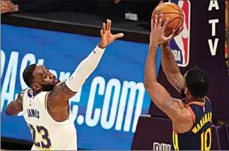  ?? MARK J. TERRILL / AP ?? Warriors guard Brad Wanamaker, right, shoots as Lakers forward LeBron James defends during the first half Sunday in Los Angeles.