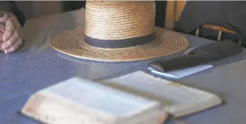  ?? JESSIE WARDARSKI/AP ?? Bishop Marvin’s straw hat sits on his living room table next to his Bible in German as he prepares for the Sunday service in Ephrata. The Old Order Stauffer Church, which shuns most modern technology including the internet, telephones and cars, has been isolated in the Mennonite Valley without church service as it followed the state’s COVID-19 stay-at-home order.