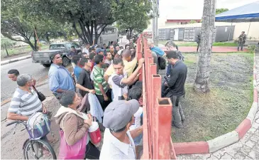  ?? AFP ?? Venezuelan refugees queue outside the UNHCR’s Jardim Floresta Camp in Boa Vista, Brazil after the federal court ordered a block on Venezuelan­s crossing the border overland.