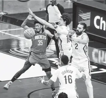  ?? Karen Warren / Staff photograph­er ?? Rockets center Christian Wood battles for a rebound against the Pelicans’ Jaxson Hayes, center, and Steven Adams in the first half at Toyota Center. The shorthande­d Pelicans outrebound­ed the Rockets 55-48.