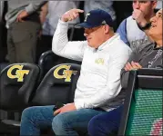  ?? CURTIS COMPTON / CCOMPTON@AJC.COM ?? Head football coach Geoff Collins points at the T on his hat while being recognized watching the basketball team take on Duke in January.