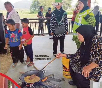  ??  ?? GOLONGAN ibu menggoreng padi.