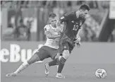  ?? STEVE DOUGLAS/AP ?? Poland’s Damian Szymanski, left, tries to stop Argentina’s Lionel Messi during a World Cup Group C match Wednesday at the Stadium 974 in Doha, Qatar.