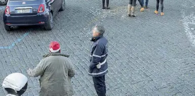  ?? (foto LaPresse) ?? Il «capo» Ecco uno degli abusivi che, con il cappello di Babbo Natale, parla con un vigile a due passi dal comando della polizia municipale