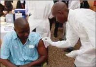  ?? AP PHOTO ?? In this file photo, a health worker, right, cleans a man’s arm before injecting him with a Ebola vaccine in Conakry, Guinea. An experiment­al vaccine tested on thousands of people in Guinea exposed to Ebola seems to work and might help shut down the...