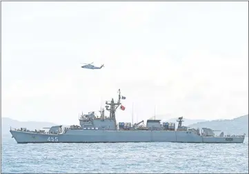  ??  ?? A helicopter and a Thai navy vessel search the area as rescue operations continue.