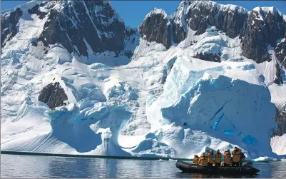  ?? WANG YANAN / FOR CHINA DAILY ?? Chinese tourists take photos near the South Pole.