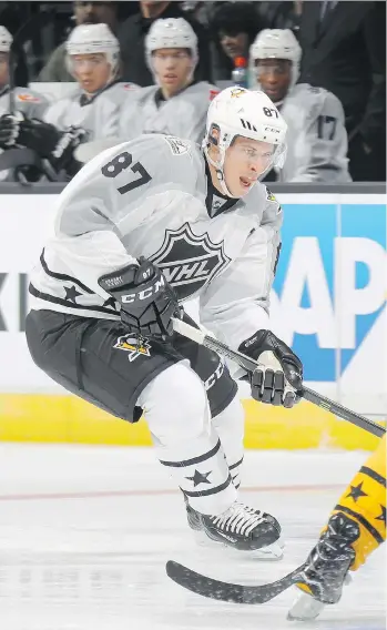  ?? BRUCE BENNETT/GETTY IMAGES ?? Metropolit­an captain Sidney Crosby carries the puck in an all-star tournament match against the Atlantic Division on Sunday in Los Angeles. Crosby scored his first all-star point in the game.