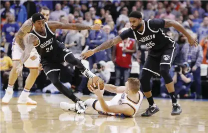 ?? —AP ?? OKLAHOMA CITY: Oklahoma City Thunder forward Domantas Sabonis, bottom, works to keep the ball away from Brooklyn Nets forward Rondae Hollis-Jefferson, left, and forward Trevor Booker, right, during the first half of an NBA basketball game in Oklahoma...