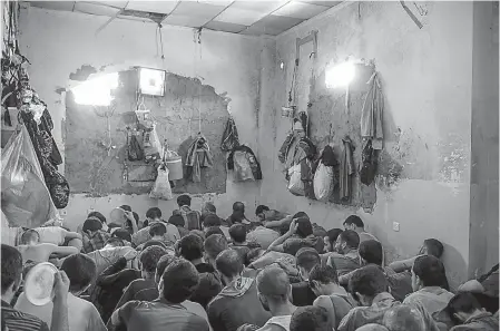  ?? Associated Press ?? Suspected Islamic State members sit inside a small room Tuesday in a prison south of Mosul, Iraq. Hundreds of suspected Islamic State members swept up by Iraqi forces in Mosul are being held in a cramped and stifling prison just outside the city.