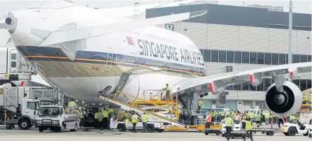  ?? REUTERS ?? Airport workers crowd around the first scheduled commercial flight of an Airbus A380 after it landed at Sydney Internatio­nal Airport after flying from Singapore on October 25, 2007.