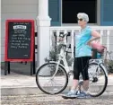  ??  ?? A cyclist takes a break Mondayat the town square at Lake Sumter Landing. Biking has shot up in popularity of late.